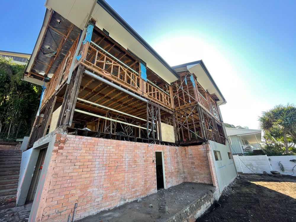 An Excavator Is Moving Rocks on A Construction Site — Lifestyle Demolition in Kingscliff, NSW