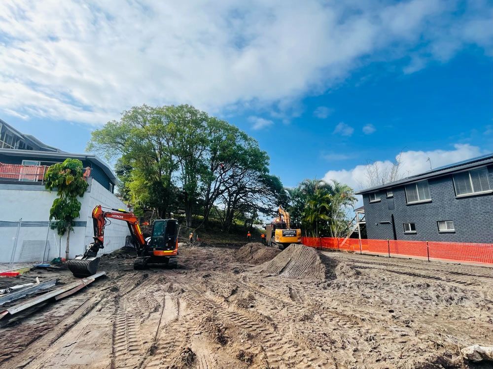 A Yellow Excavator Is Digging a Pile of Dirt on A Construction Site — Lifestyle Demolition In Murwillumbah, NSW