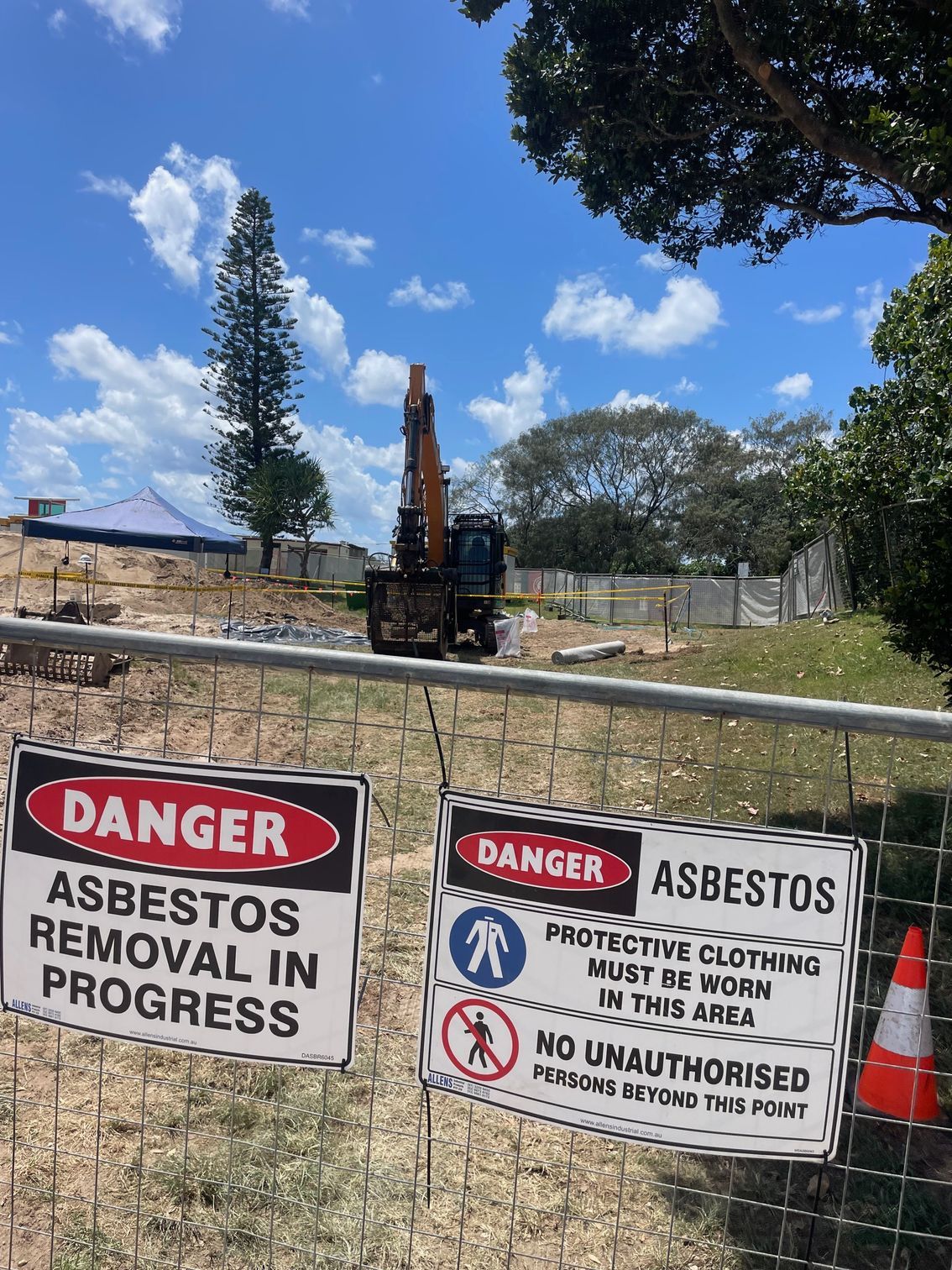 A Skid Steer Loader With A Full Bucket Of Dirt Clearing Land Next To A White Wall — Lifestyle Demolition In Kingscliff, NSW