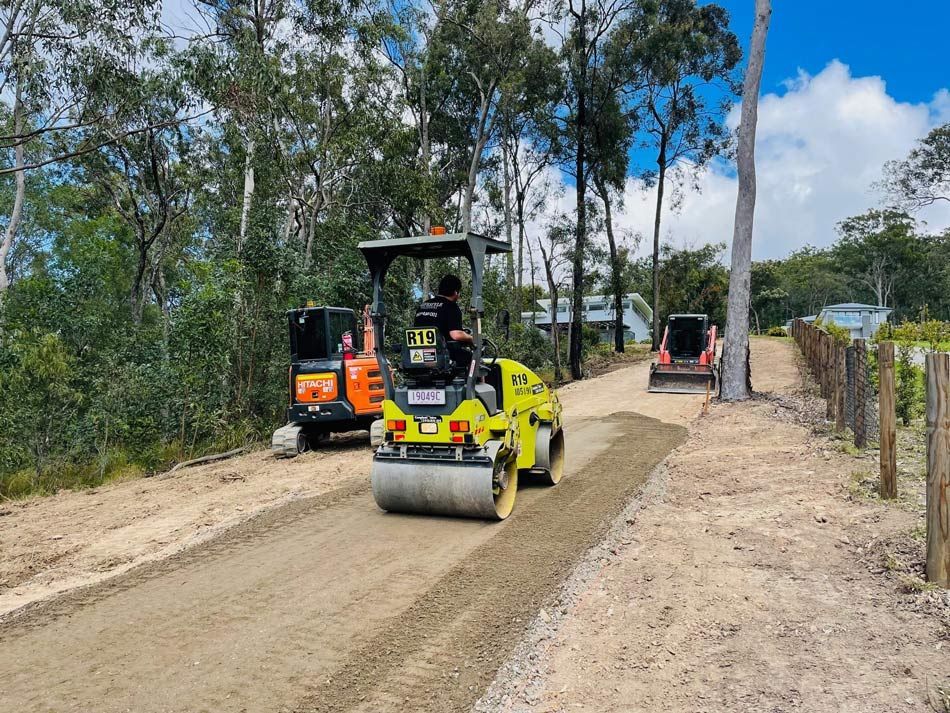 A Yellow Excavator Is Moving Dirt on Top of A Pile of Rocks — Lifestyle Demolition in Kingscliff, NSW