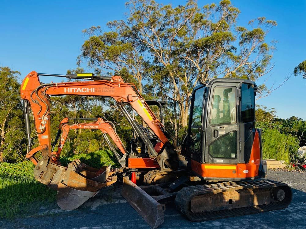 Two Hitachi Excavators Are Parked Next to Each Other on A Dirt Road — Lifestyle Demolition in Kingscliff, NSW