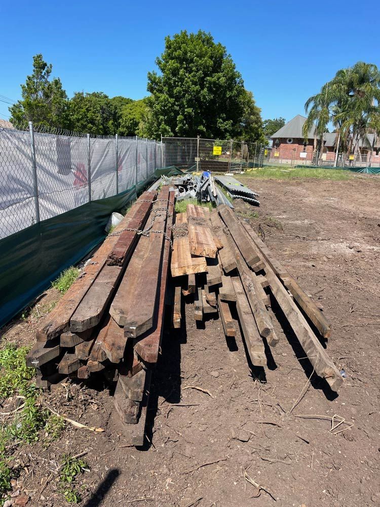 A Yellow Excavator Is Demolishing a Building on A Construction Site — Lifestyle Demolition In Mullumbimby, NSW
