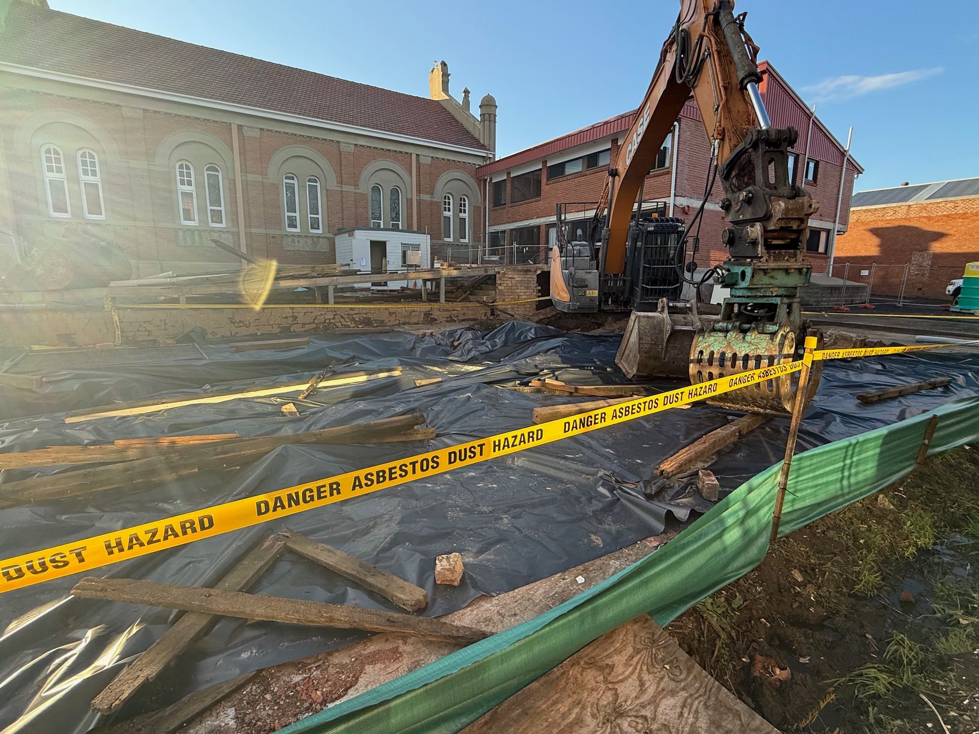 An Excavator Loading A White Dump Truck With Red Soil On A Sunny Day — Lifestyle Demolition In Kingscliff, NSW