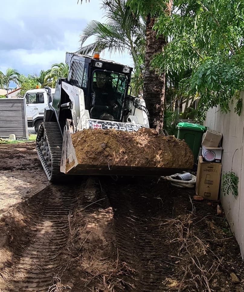 A White Bobcat Excavator With Dirt-filled Bucket Is Removing A Soil — Lifestyle Demolition In Kingscliff, NSW