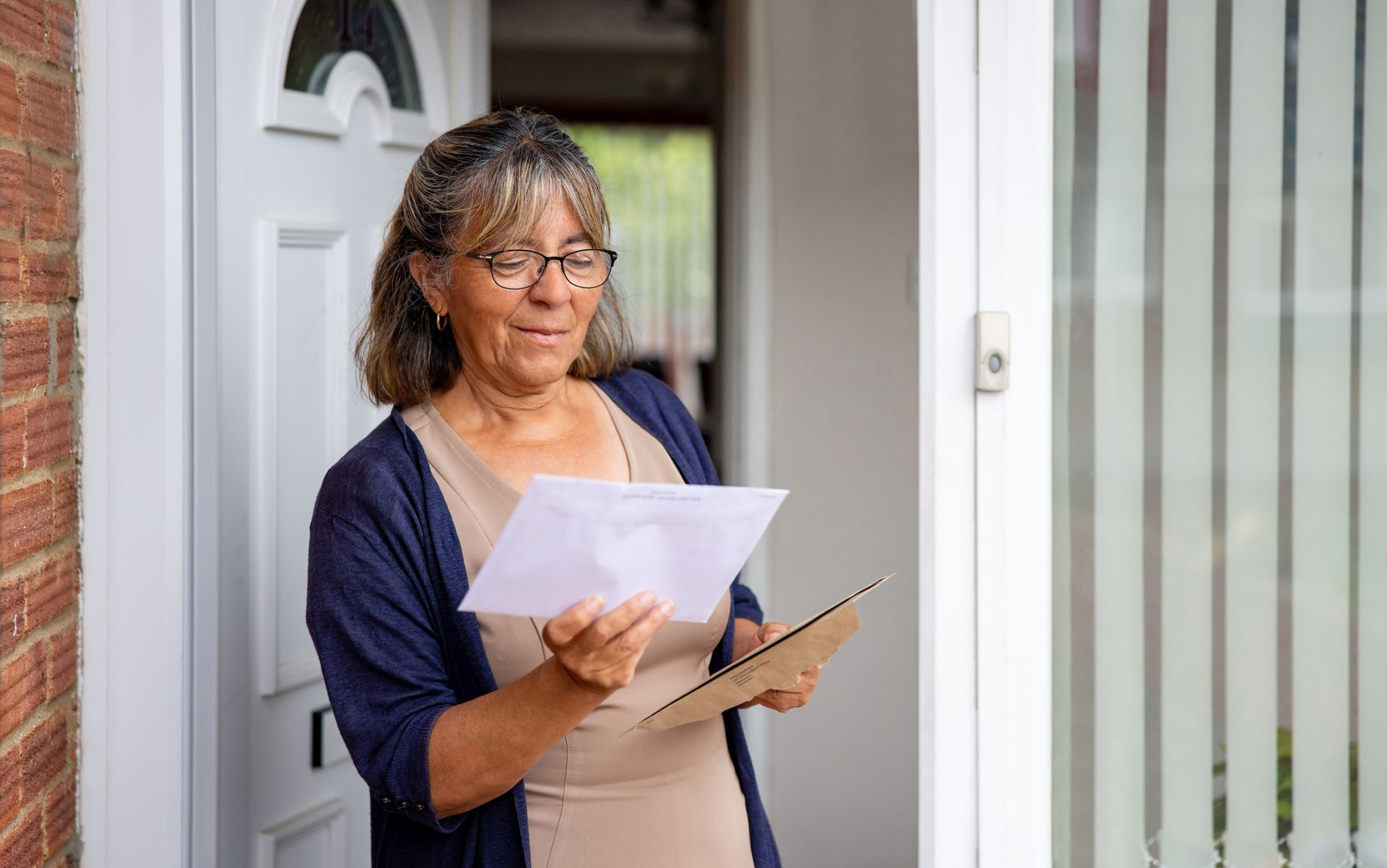 A woman standing holding a legal document given to her by a process server in n Snohomish County
