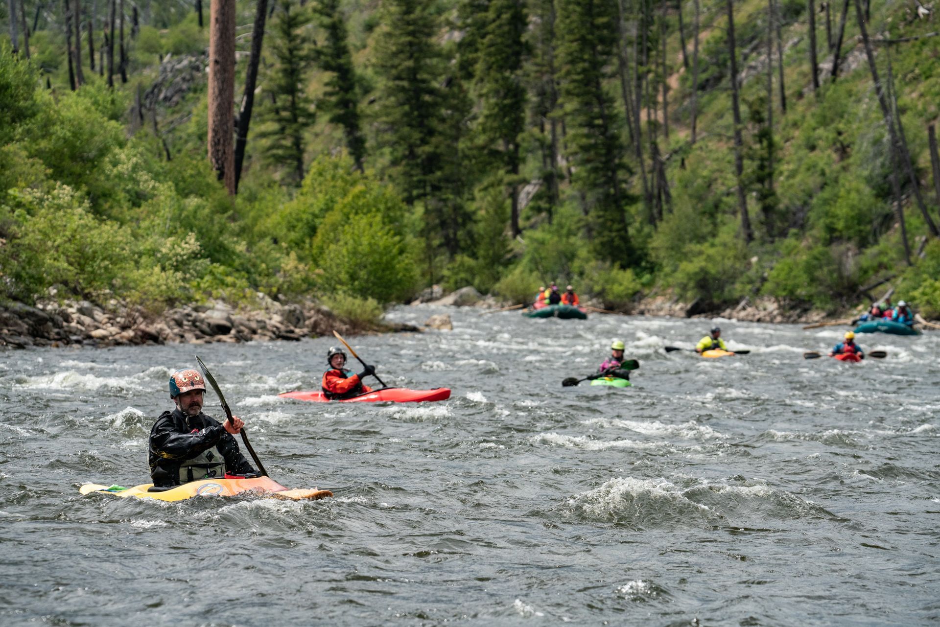 A group of people are kayaking down a river.