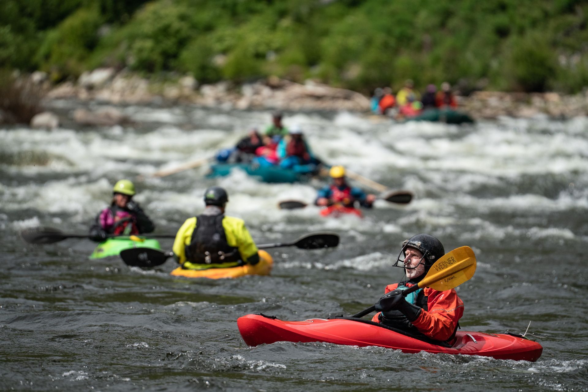 A group of people are kayaking down a river.