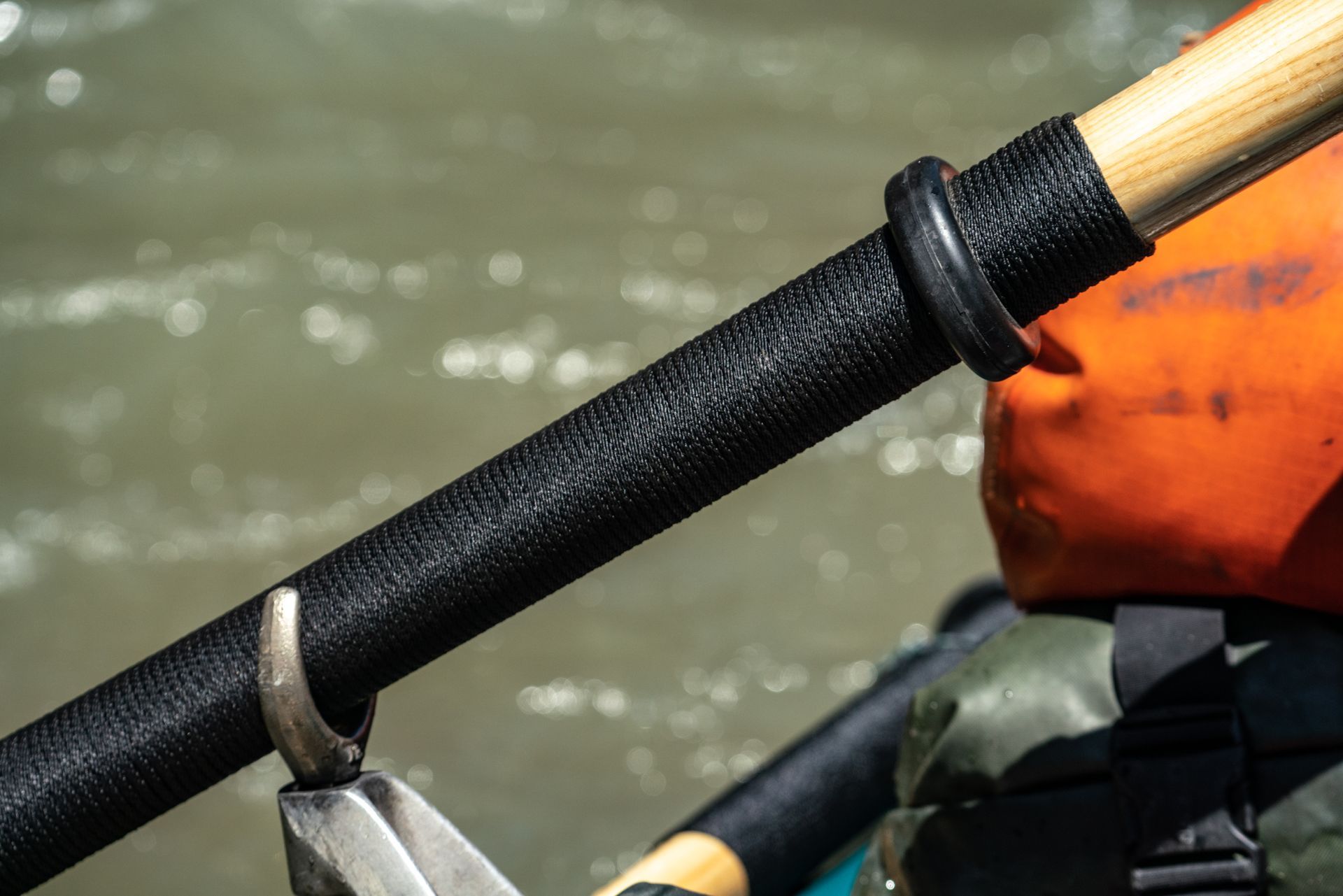 A close up of a fishing rod hanging on a hook in the water.