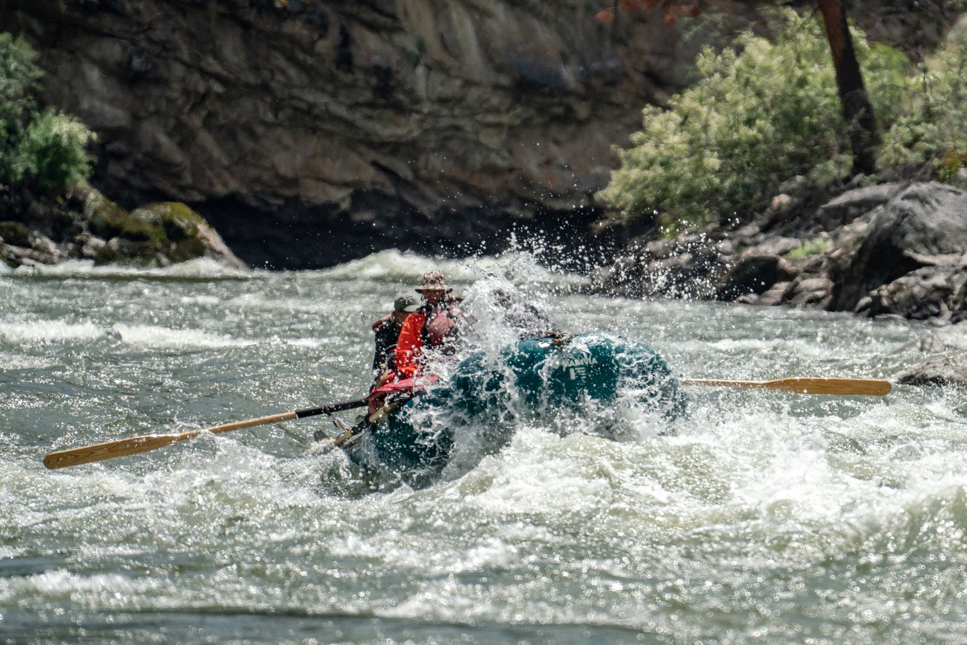 A person is rowing a raft down a river.