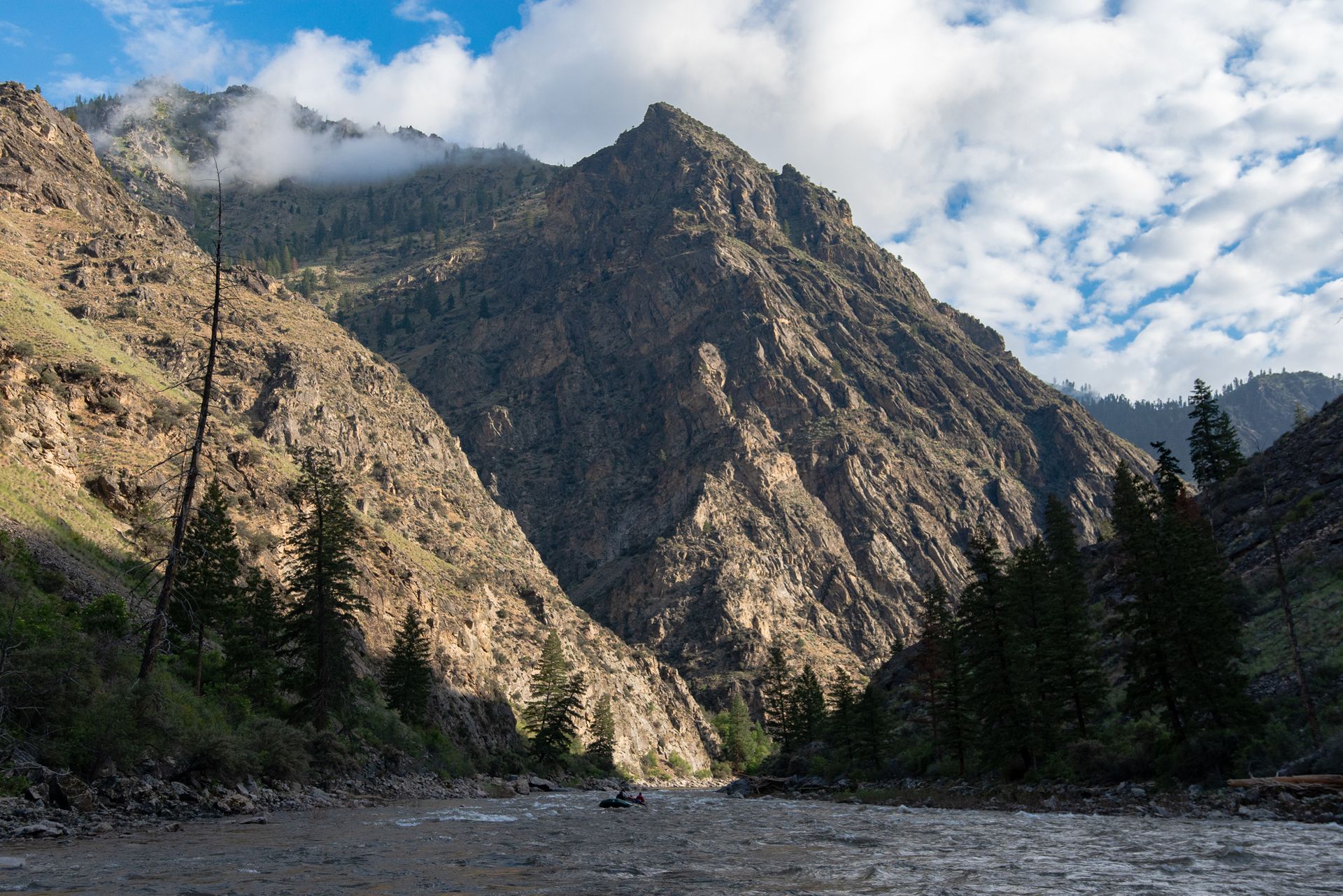 A river running through a valley with mountains in the background