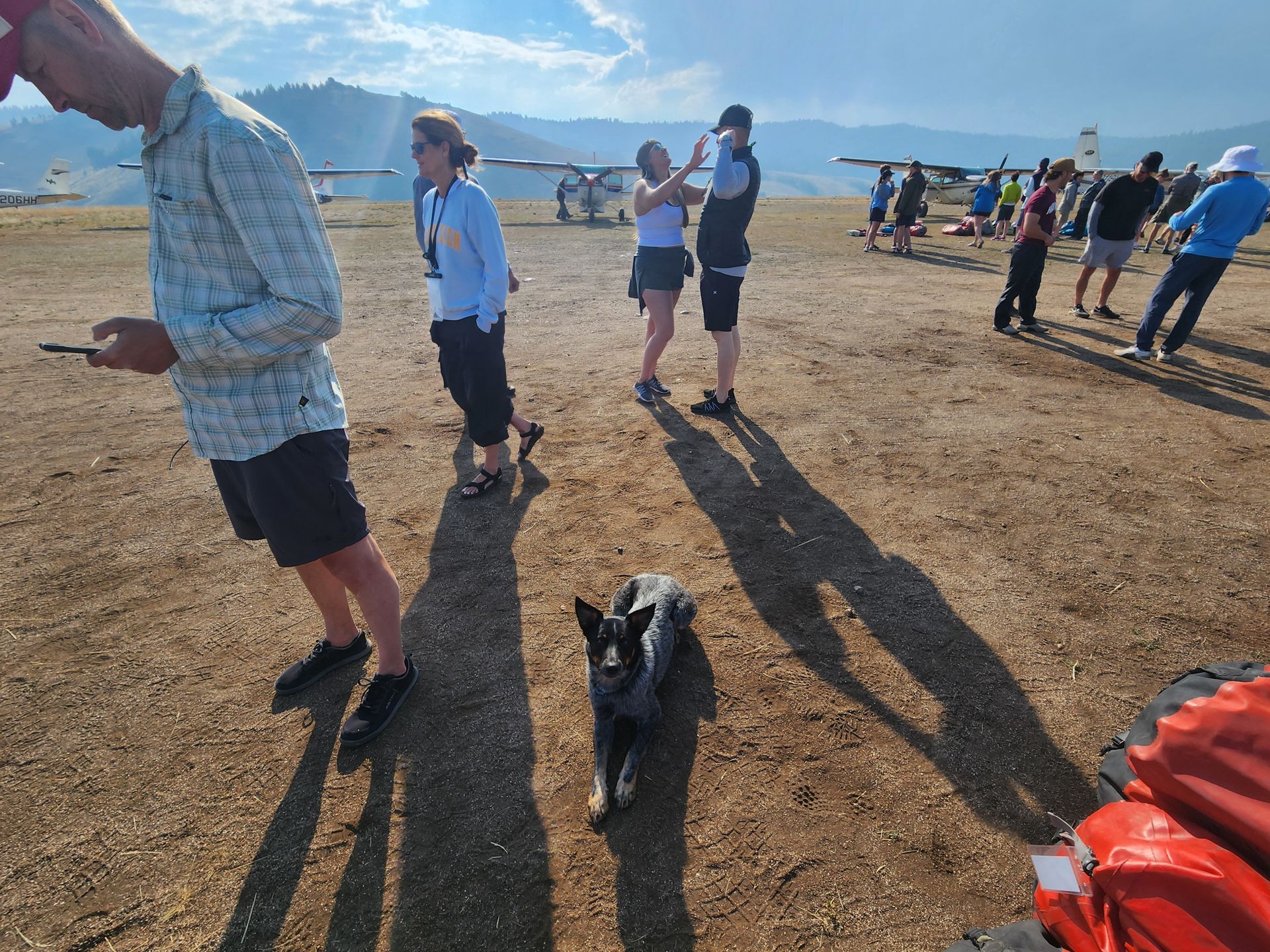 A group of people are standing in a field with a dog.