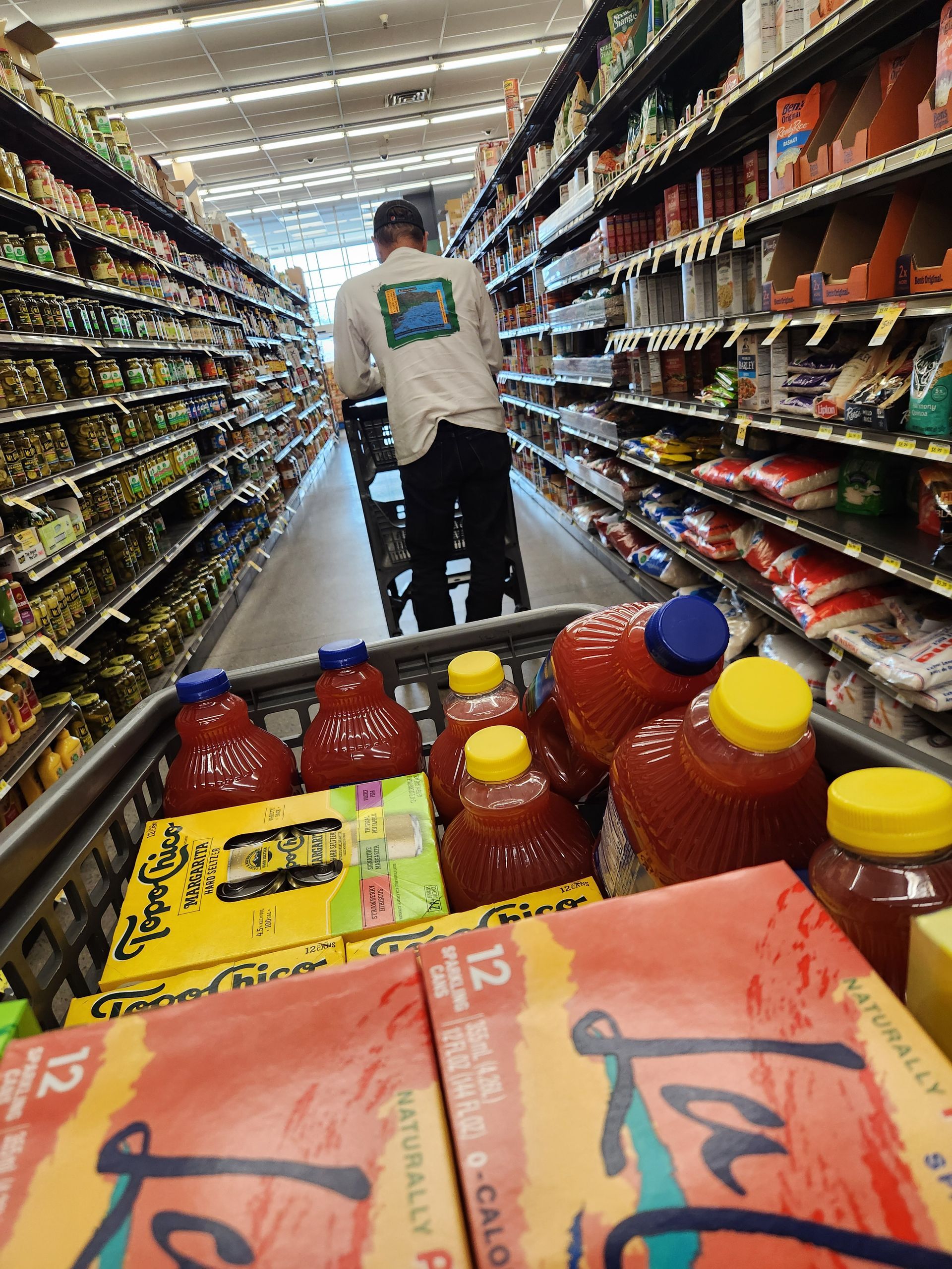 A man pushing a shopping cart in a grocery store
