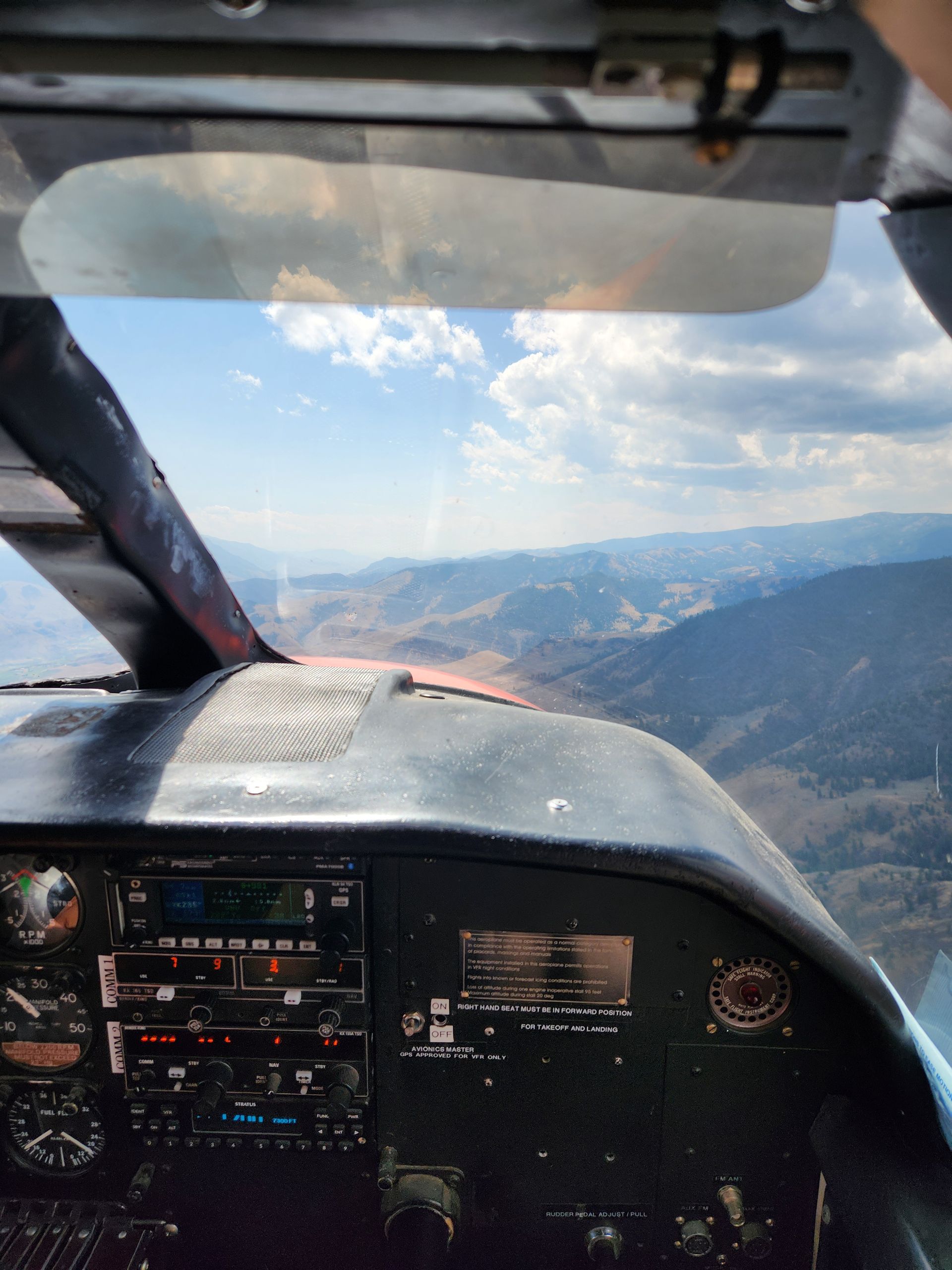 A cockpit of an airplane with mountains in the background