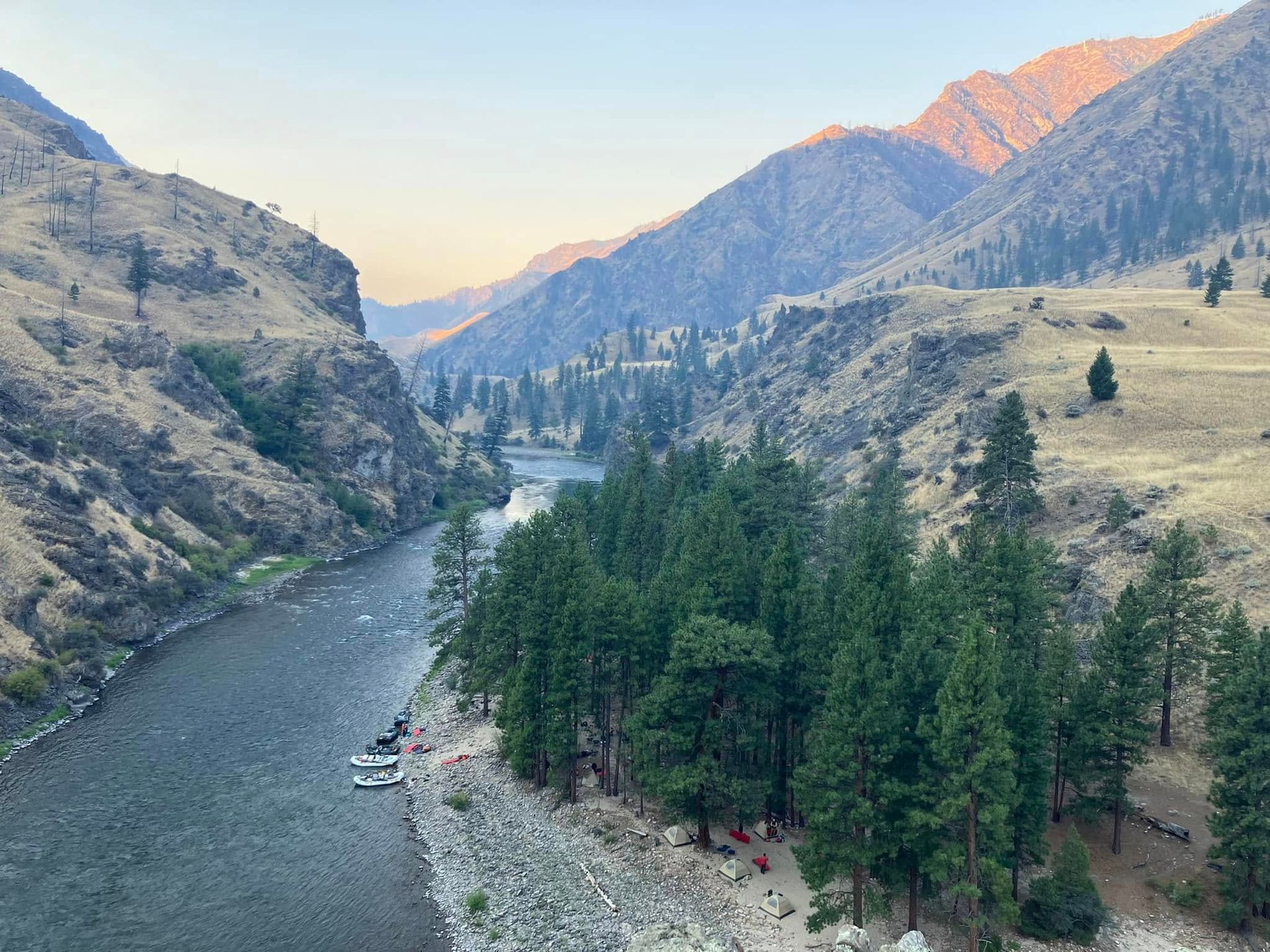 A river running through a canyon surrounded by mountains and trees.