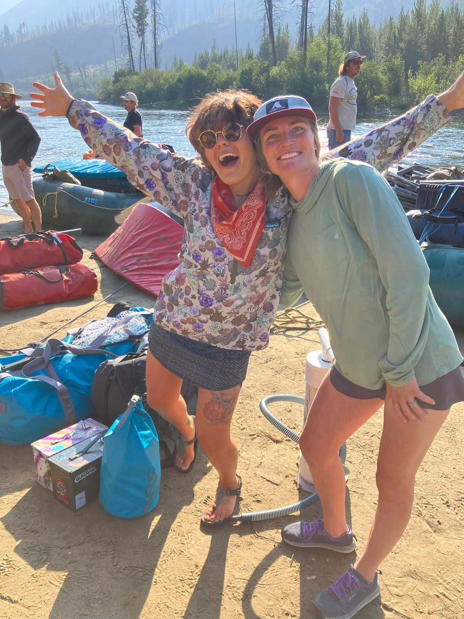 Two women are posing for a picture on the beach.