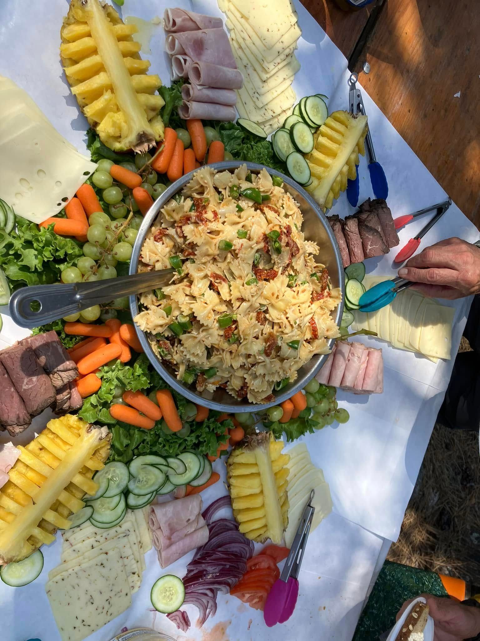 A table topped with a variety of food and a bowl of salad.
