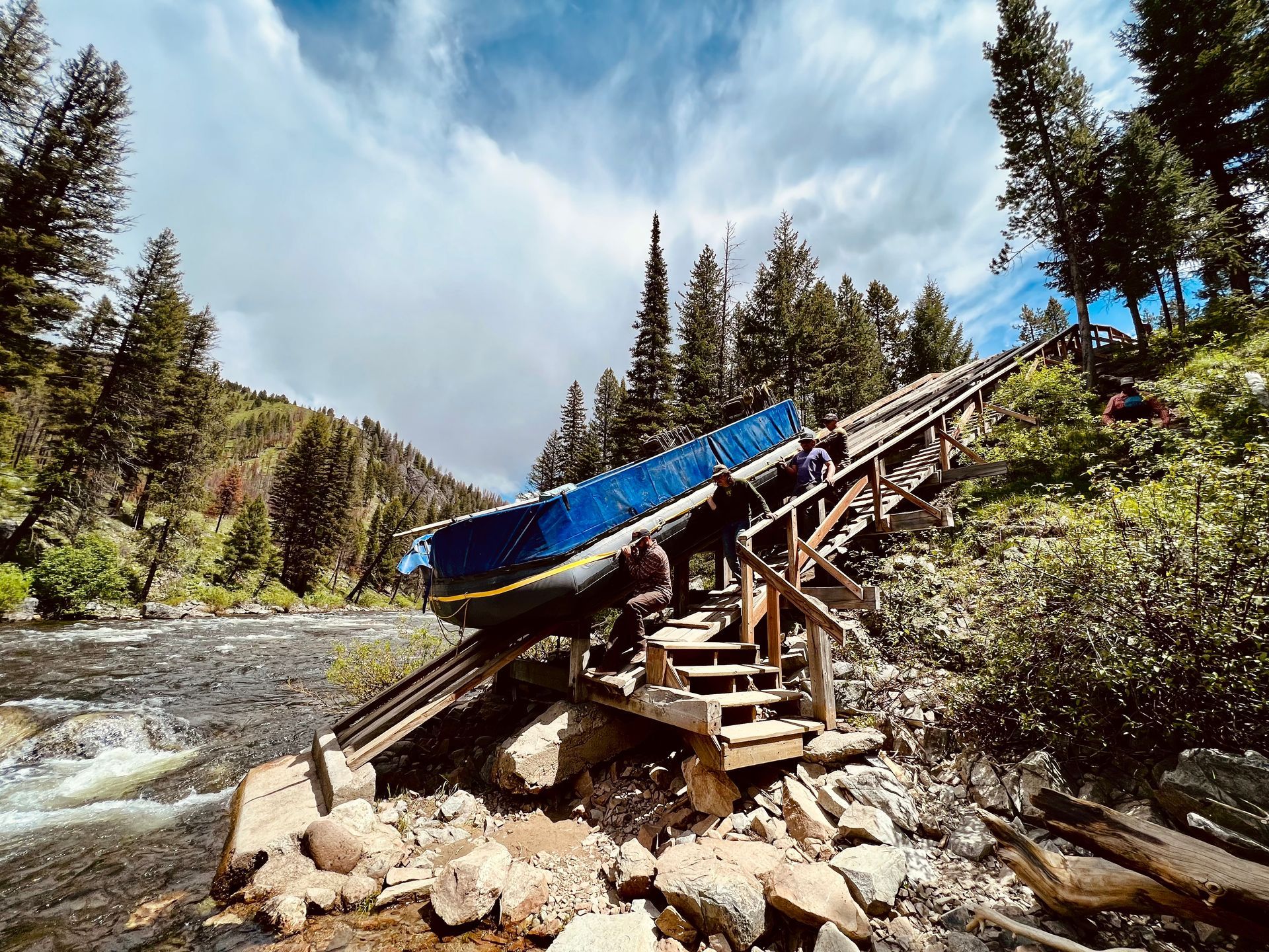 A boat is sitting on top of a wooden bridge over a river.