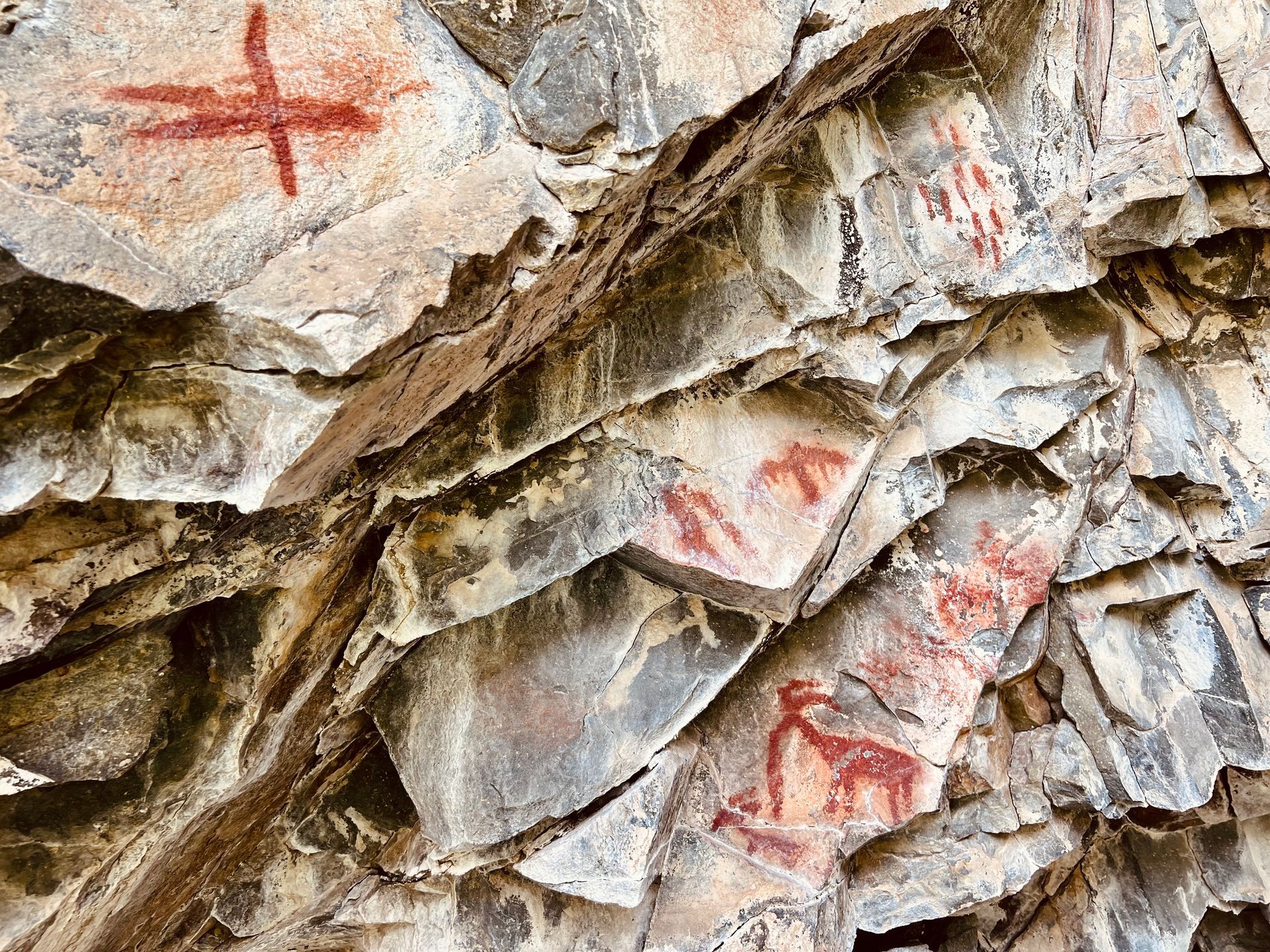A close up of a rock wall with drawings on it.