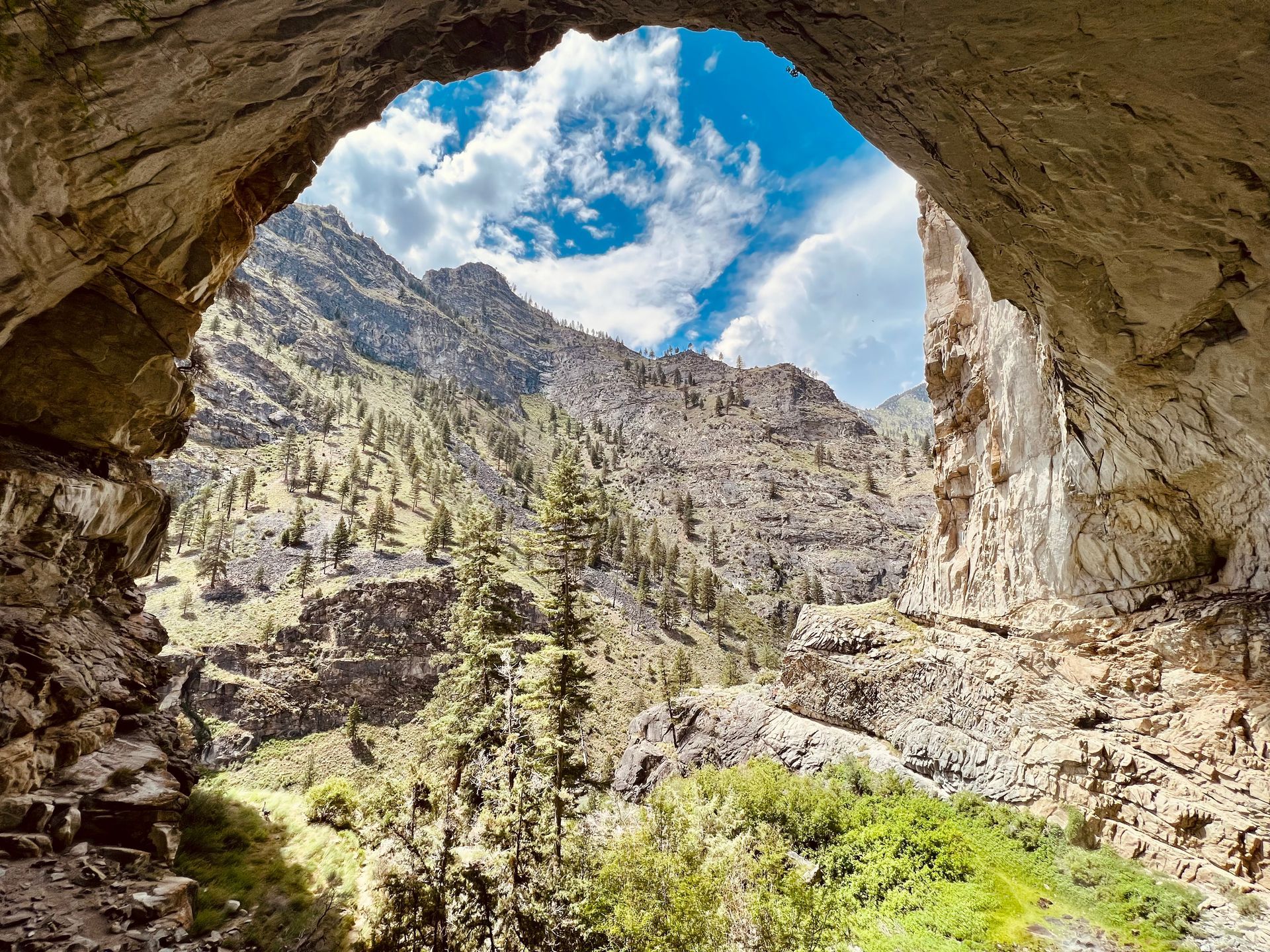 A view of a mountain range through a cave.