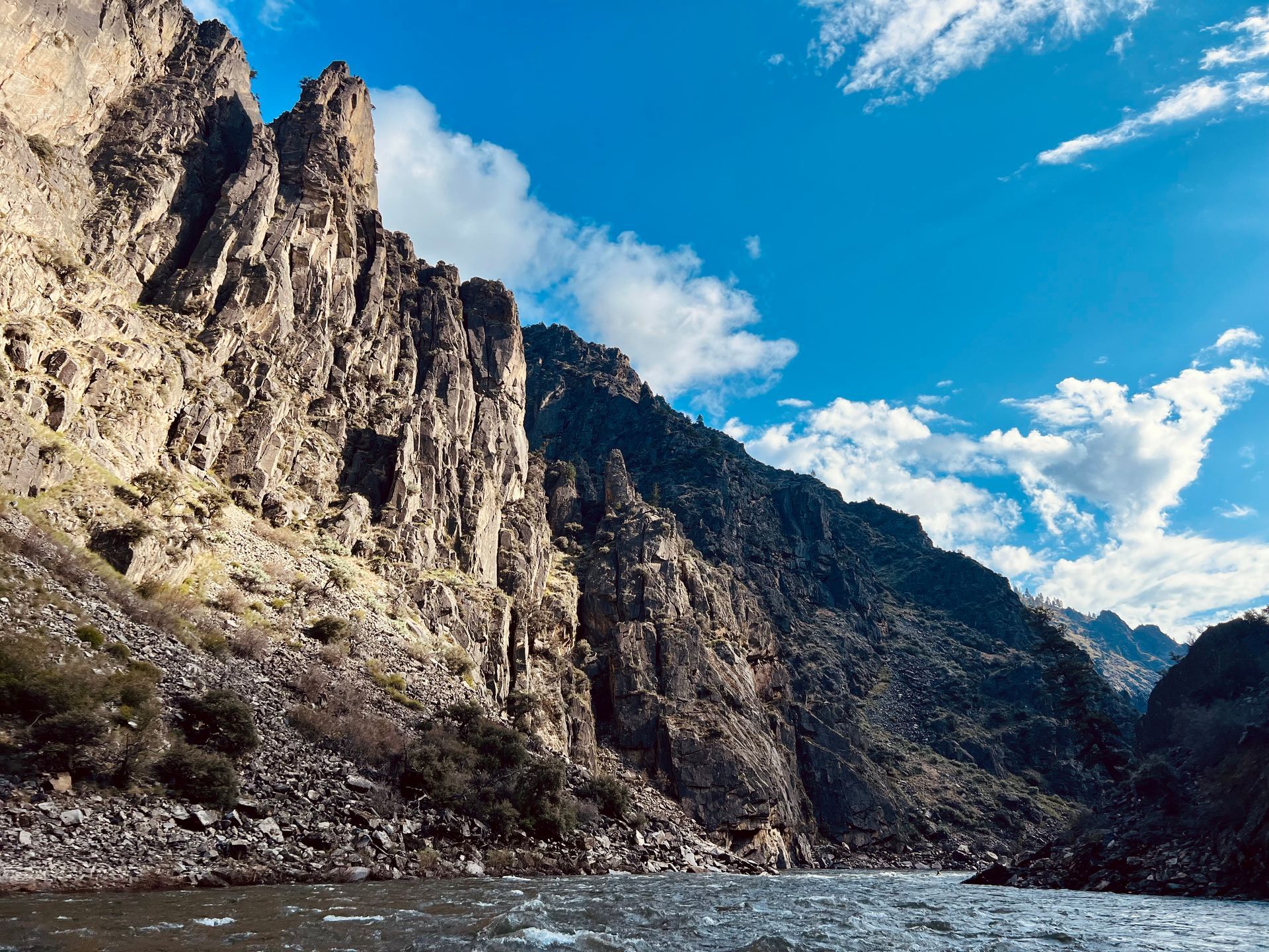 A river running through a canyon with mountains in the background