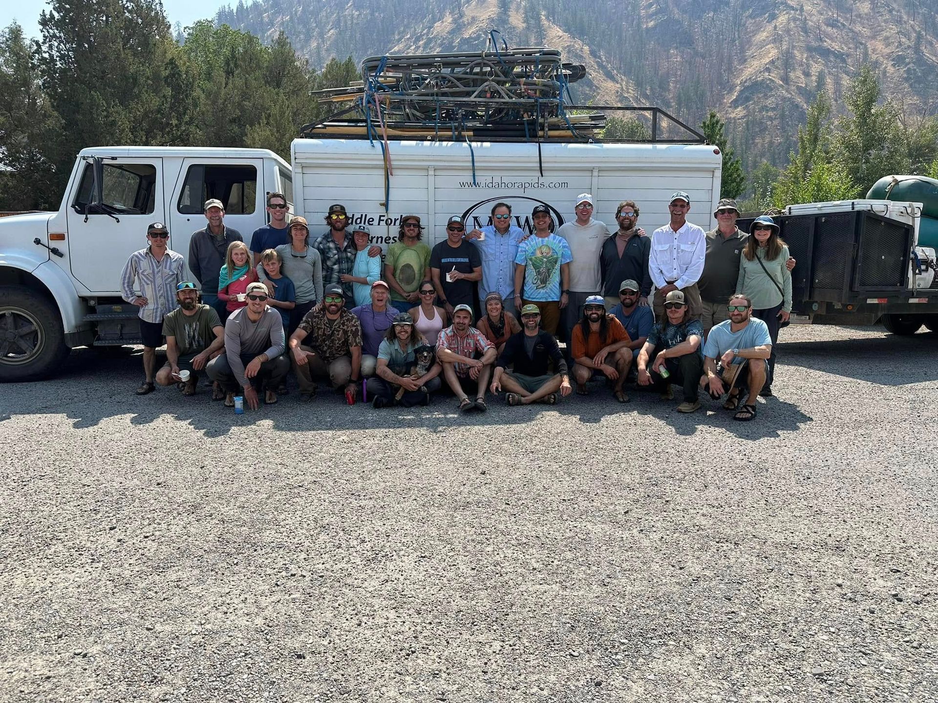 A group of people are posing for a picture in front of a truck.