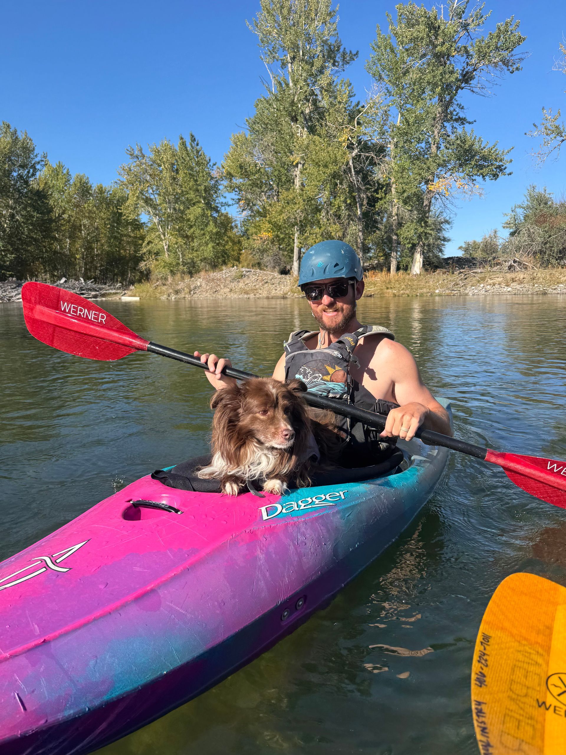 A man is sitting on the back of a boat on a river
