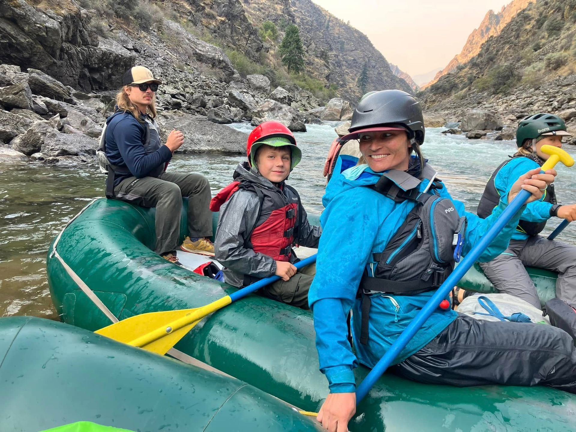 A group of people are sitting in a raft on a river.