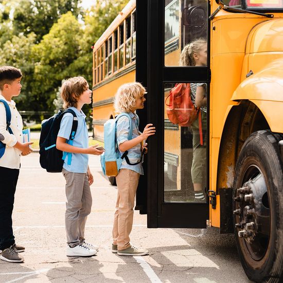 A group of children are standing next to a school bus.