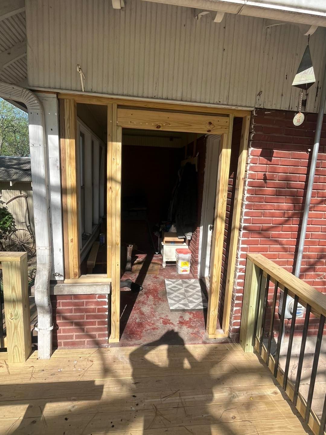Exterior doorway under construction, framed with unfinished wood, set in a 