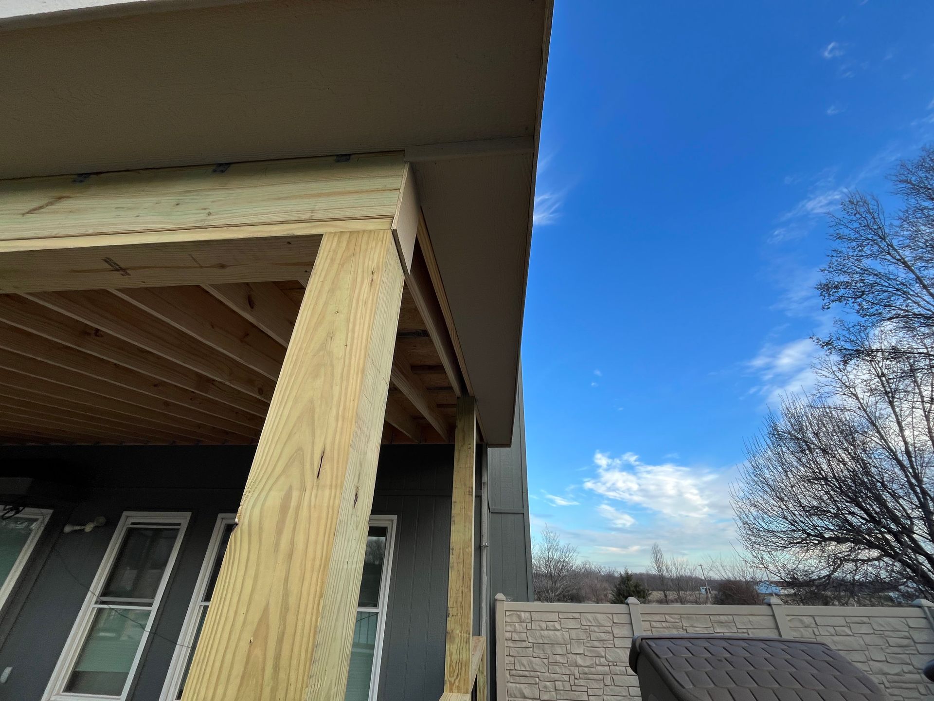 Wooden deck construction with blue sky background.