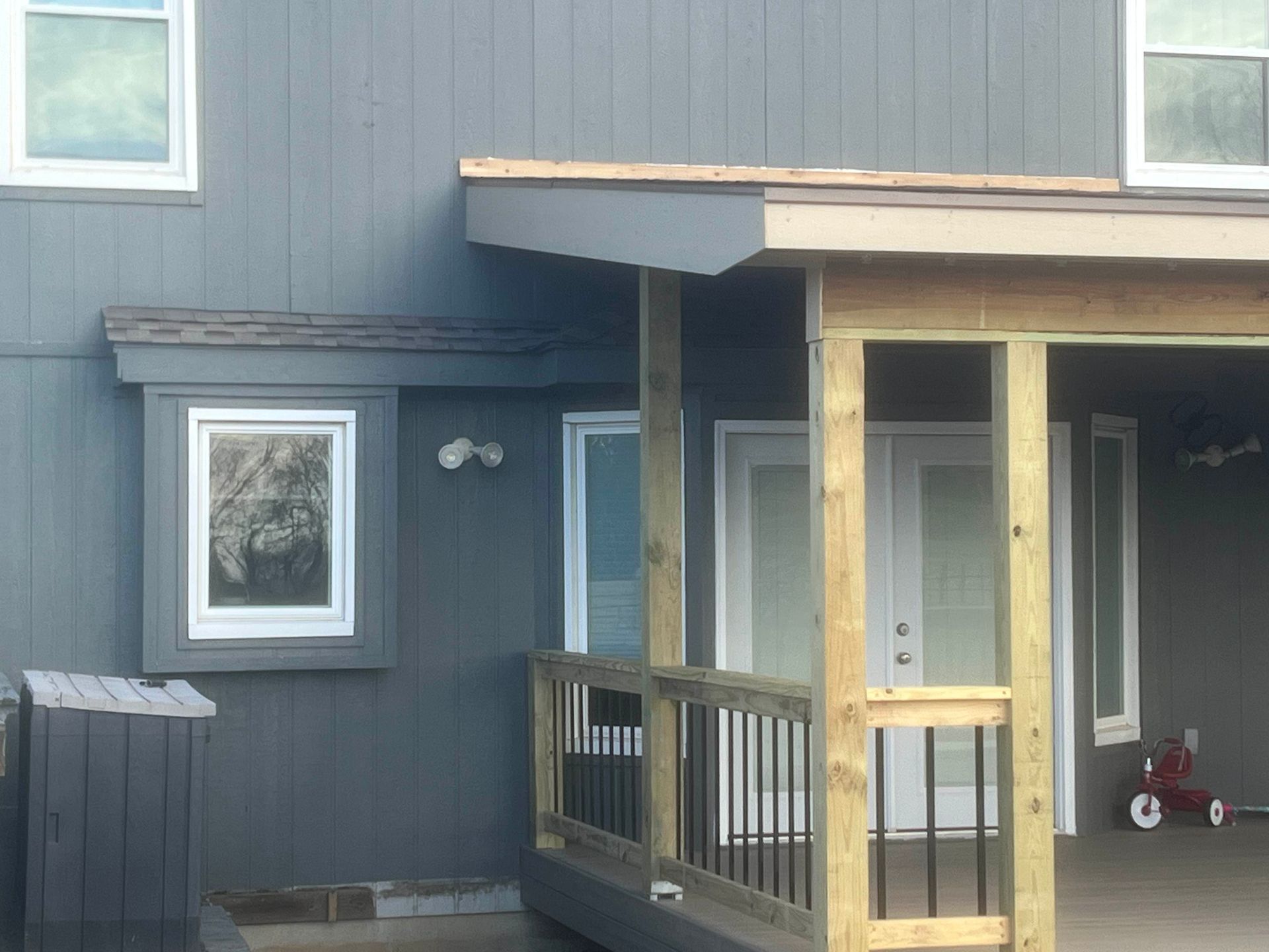 Gray house exterior with porch, windows, and deck.