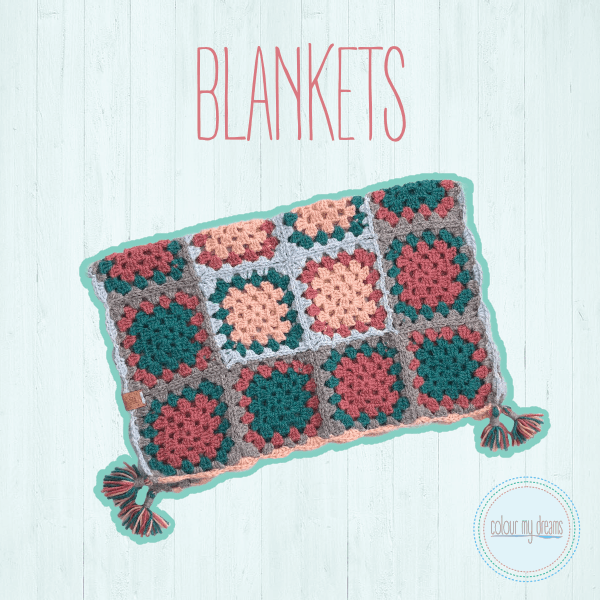 Image of a multi-coloured granny square blanket with tassels on the corners.