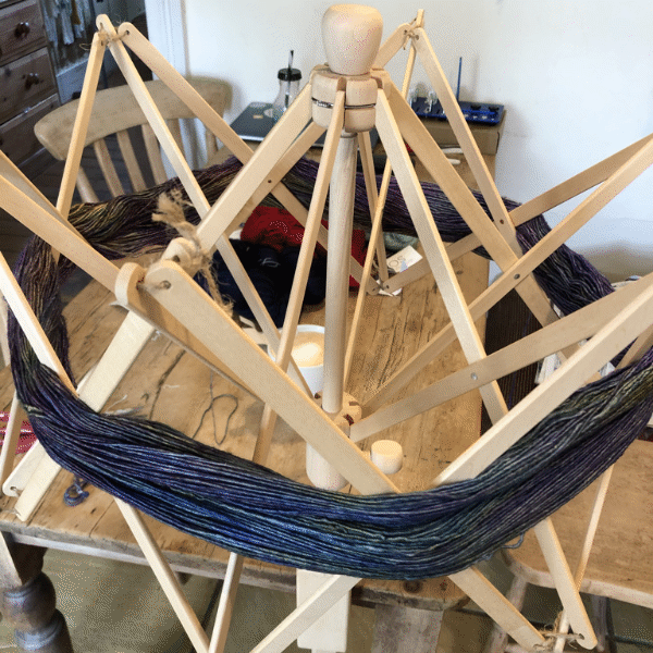 A basket of skeins for wool in grey, blue and pink
