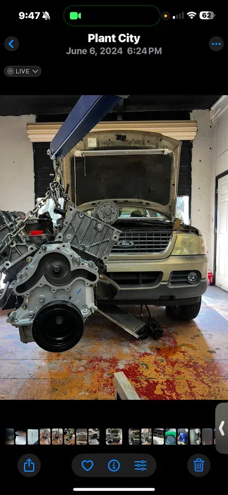 An engine removed from a vehicle in a mechanic's bay, showing blood-like stains on the floor.