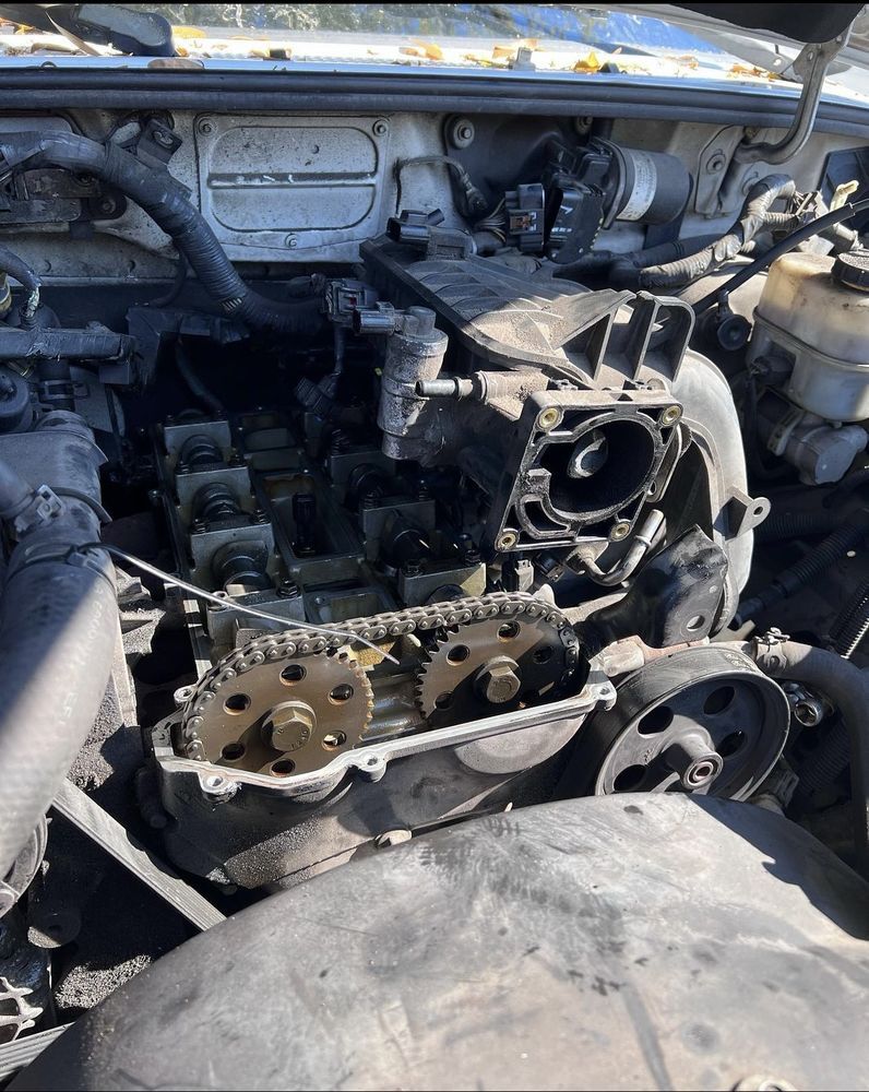 Engine bay with exposed engine components, including gears and a timing chain.