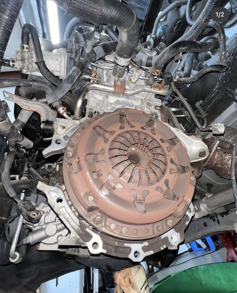 Car engine with visible clutch, viewed from below.