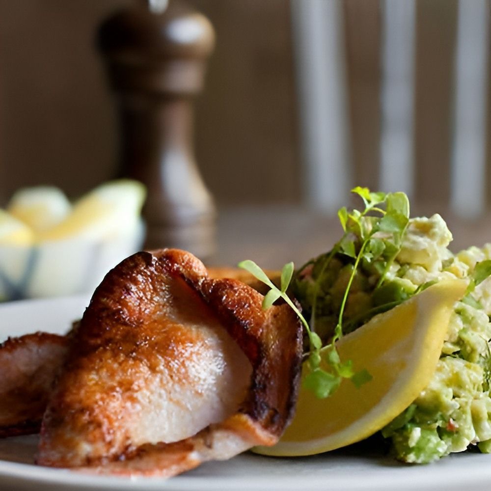 A White Plate Topped With Chicken Guacamole and a Slice of Lemon — Corrado & Frank Distributors in Fairy Meadow, NSW