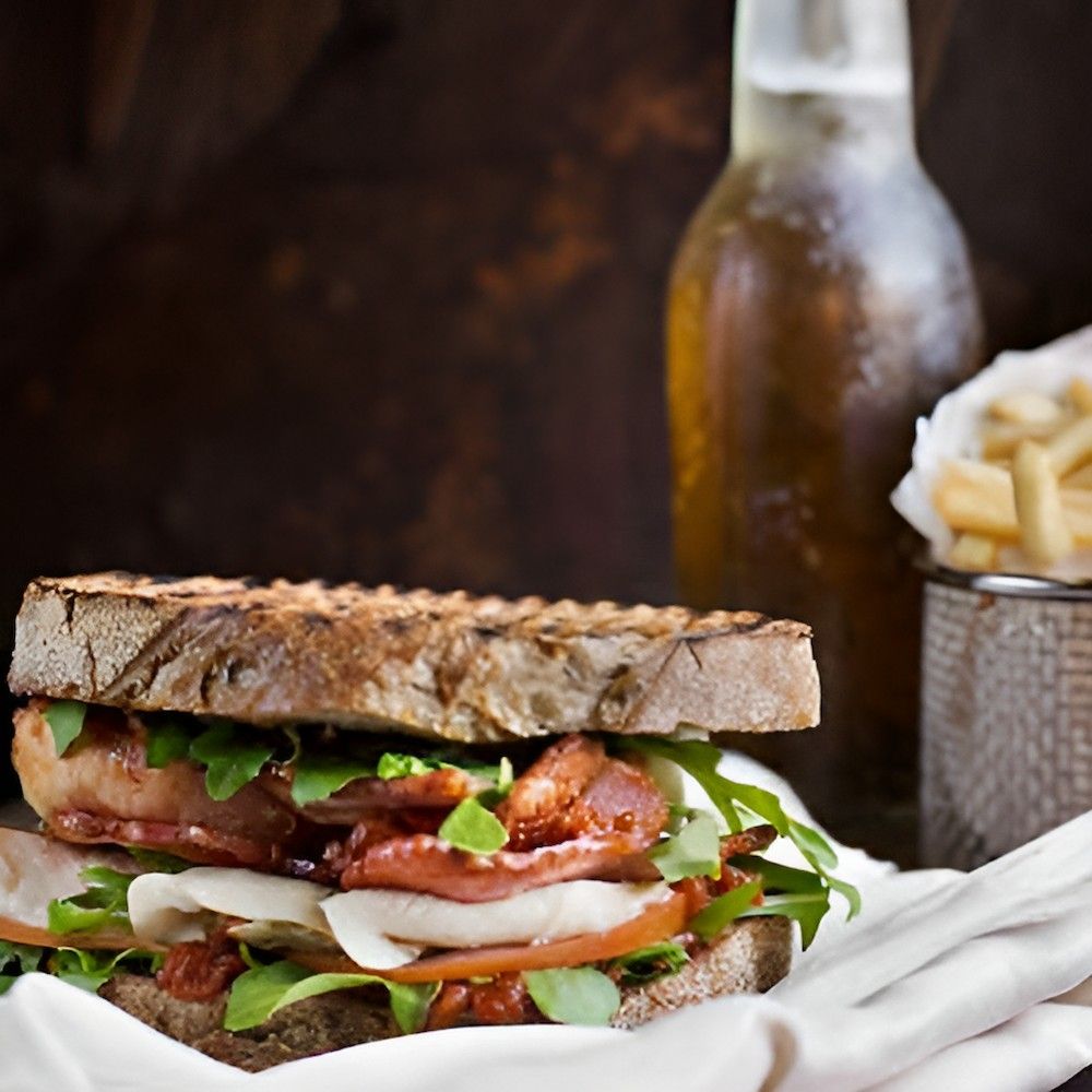 A Close Up of a Sandwich With a Bottle of Beer in the Background — Corrado & Frank Distributors in Fairy Meadow, NSW