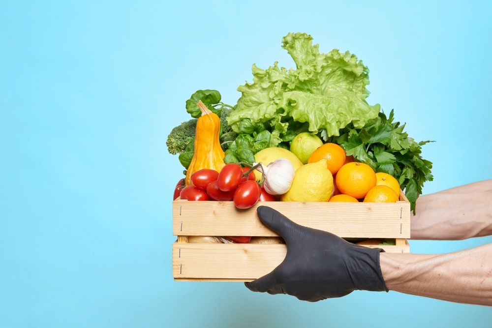 A Person Wearing Black Gloves is Holding a Wooden Box — Corrado & Frank Distributors in Illawara, NSW