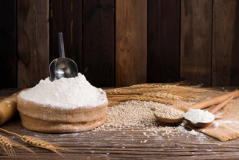 A Wooden Table Topped With A Pile Of Flour And Spoons — Corrado & Frank Distributors in Fairy Meadow, NSW