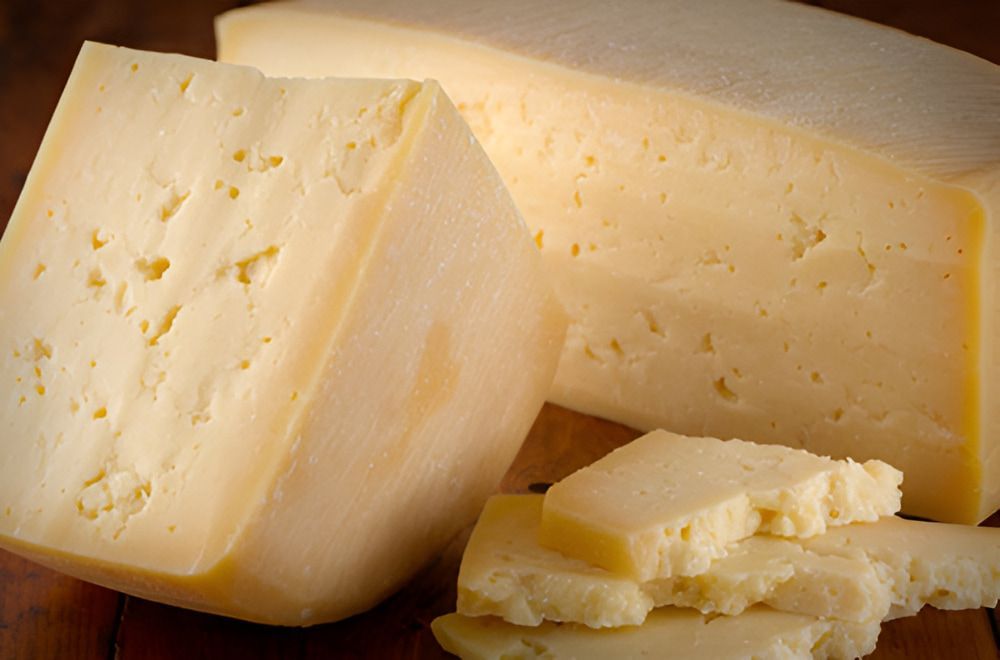 A Close Up of a Piece of Cheese on a Wooden Table — Corrado & Frank Distributors in Fairy Meadow, NSW