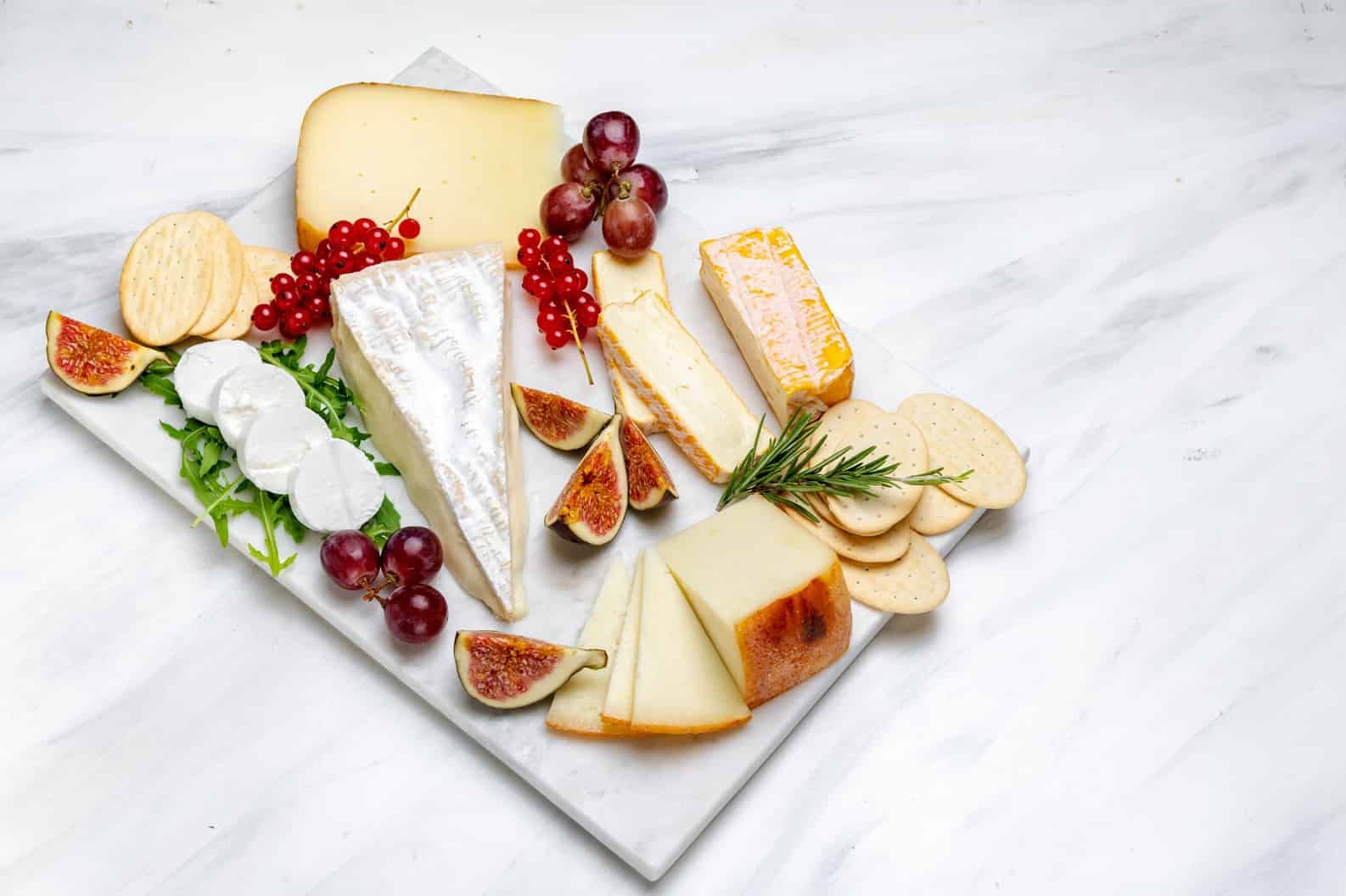 There Are Many Different Types of Cheese on the Cutting Board — Corrado & Frank Distributors in Fairy Meadow, NSW