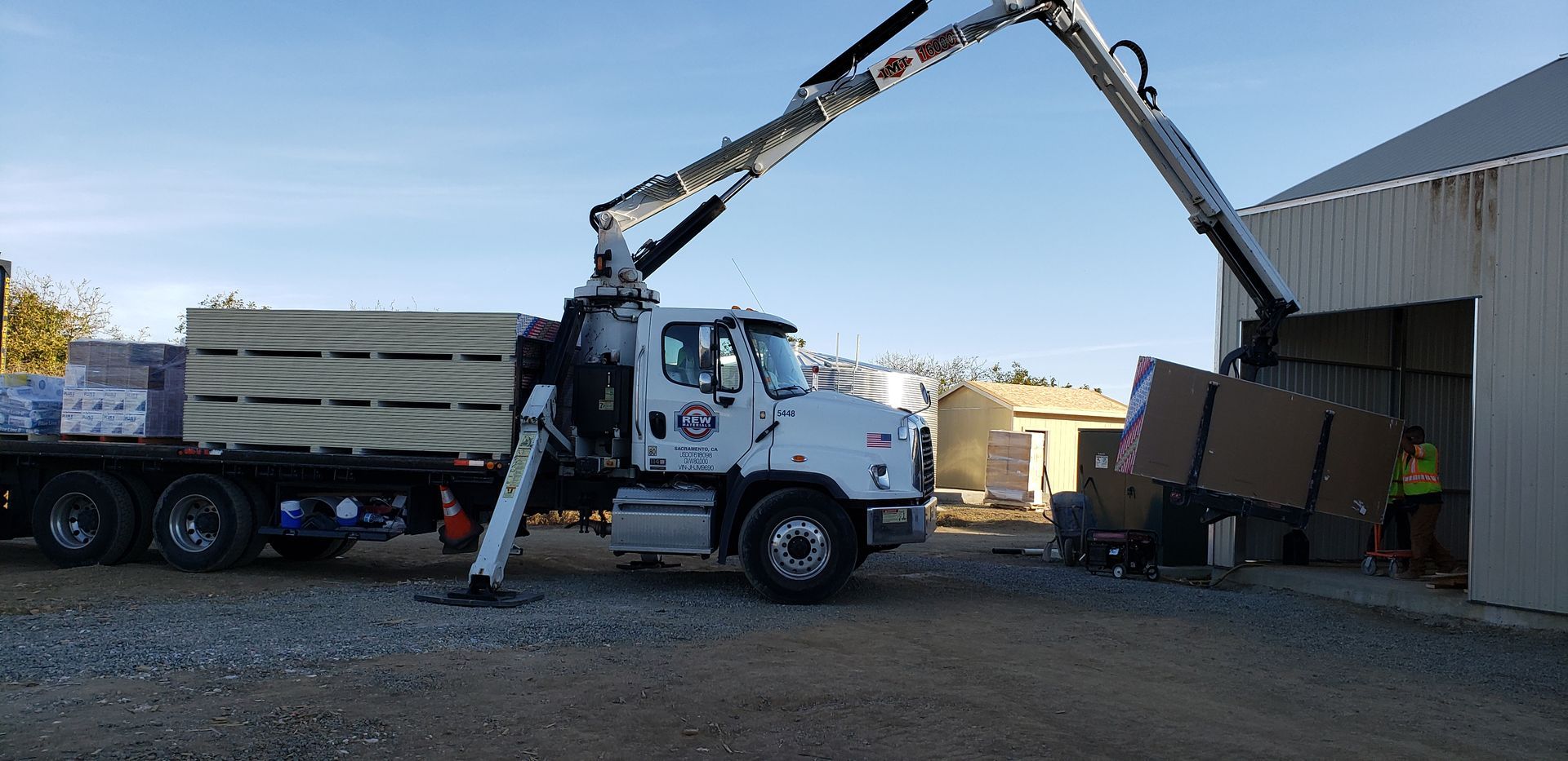 a large flatbed truck loads sheets of drywall