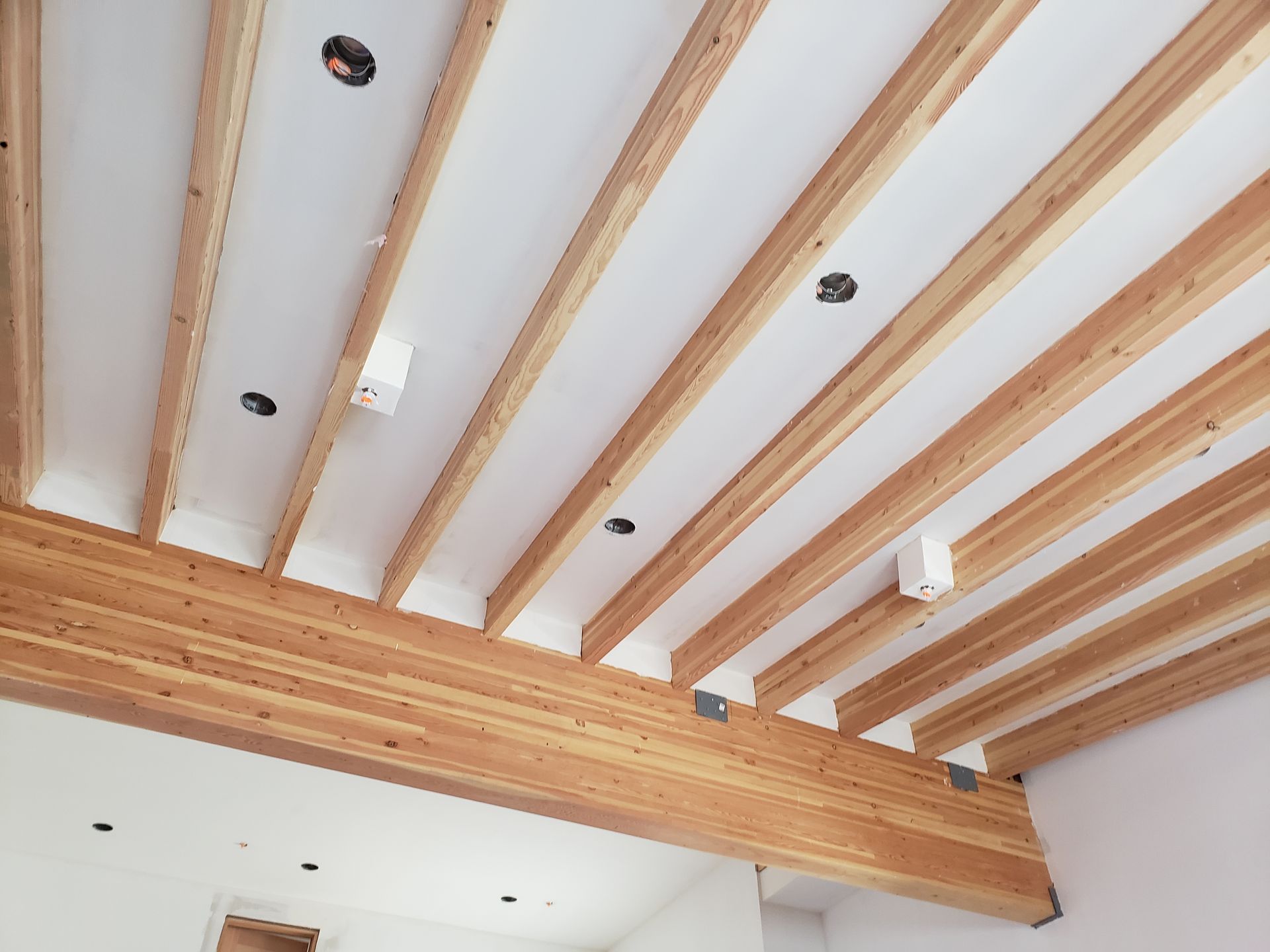 a drywall job on the ceiling with intricate work done between exposed supports