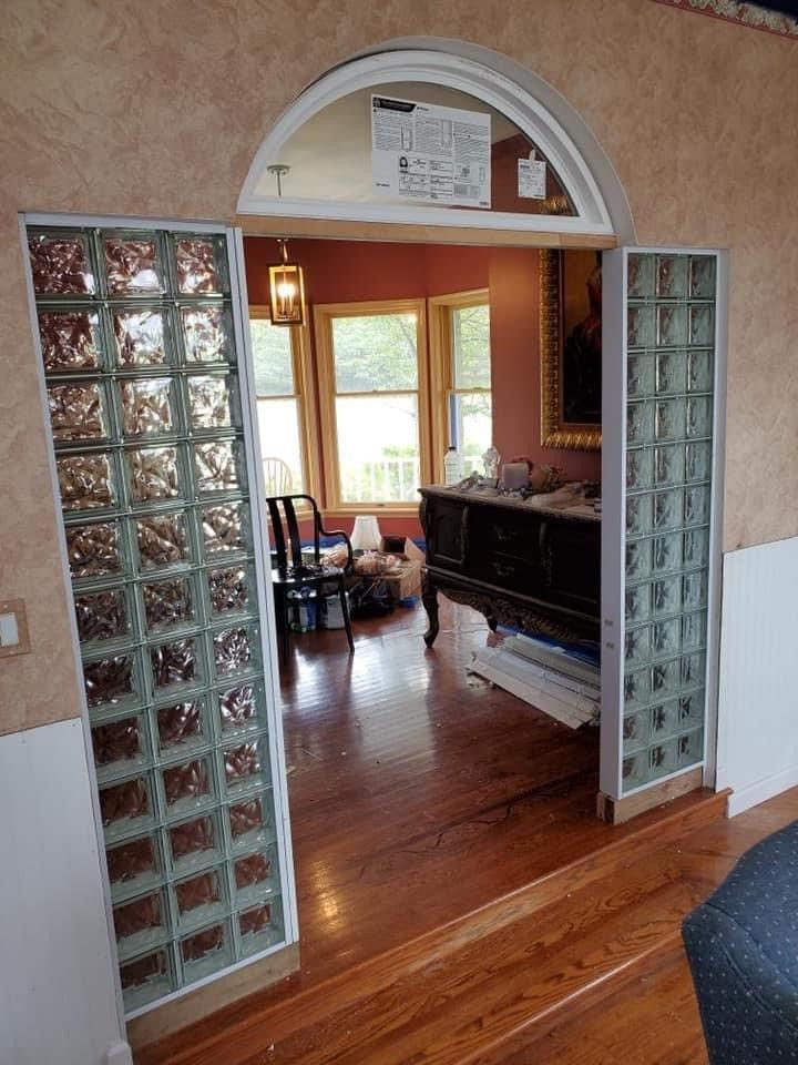 A living room with hardwood floors and a glass door leading to a dining room.