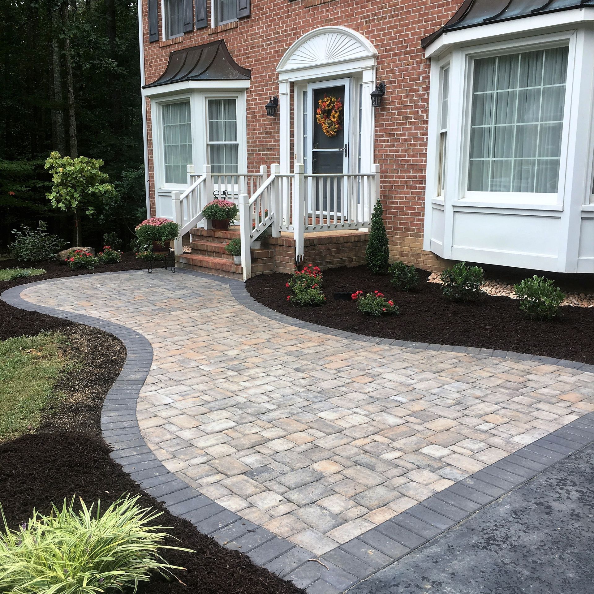 A brick house with a walkway leading to the front door