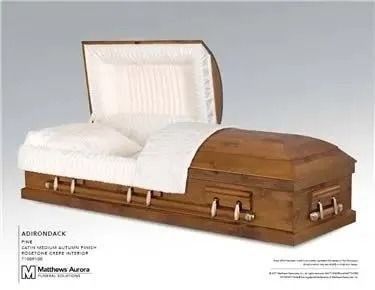 Wooden coffin with an open lid, white interior lining, and pillows.