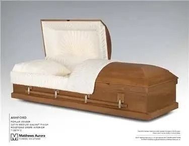 Open wooden casket with white interior and pillow.