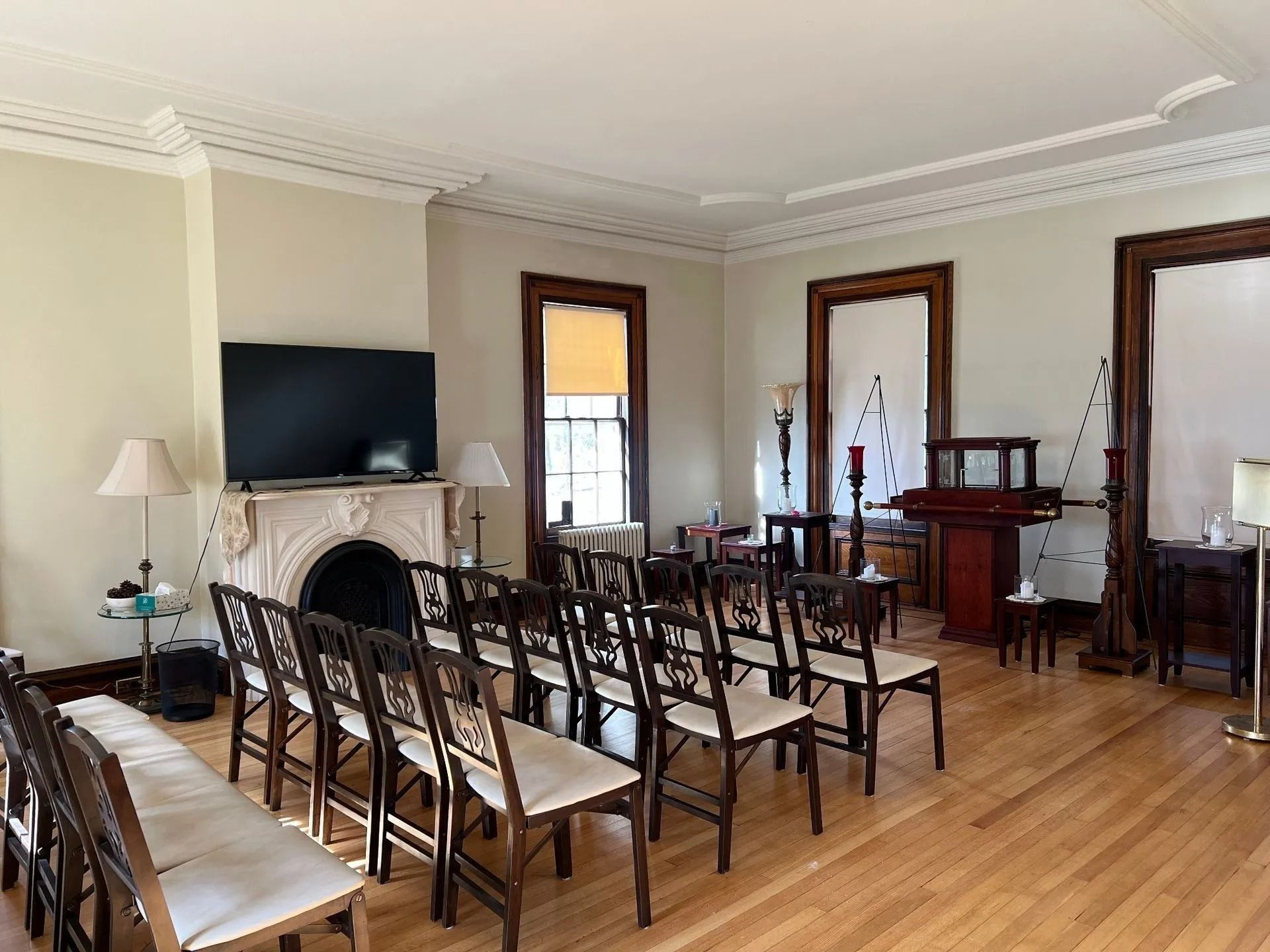 An interior room set up for a ceremony with chairs, a fireplace, and a large screen TV.