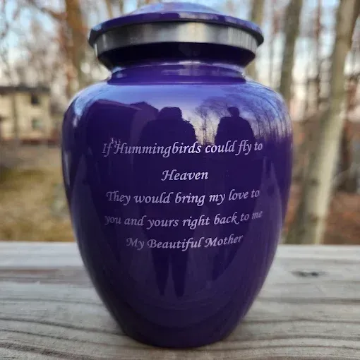 A vase sitting on top of a wooden table next to candles and a picture frame.